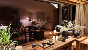 A cozy room with a wooden table set for tea, candles, and a vase of dried flowers. - Miss or Dismiss (Chongqing)