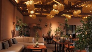 A spacious lounge area with a large sofa, wooden tables, and hanging spherical light fixtures. - Miss or Dismiss (Chongqing)