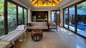 A spacious living area with a ceiling fan, large windows, and a view of the outside. - GuangPo MeiYa Homestay LingShui (Lingshui)