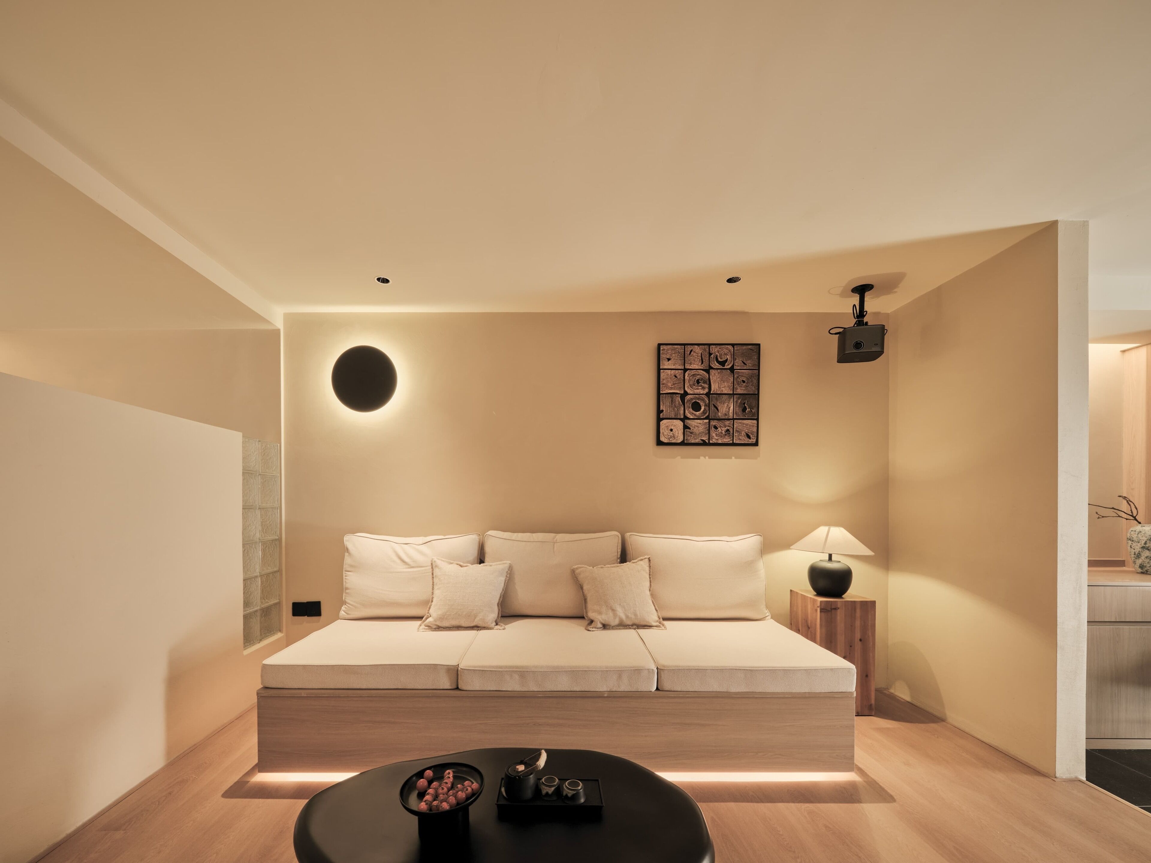 Un salon moderne avec un canapé, une table basse et une œuvre d’art accrochée au mur.