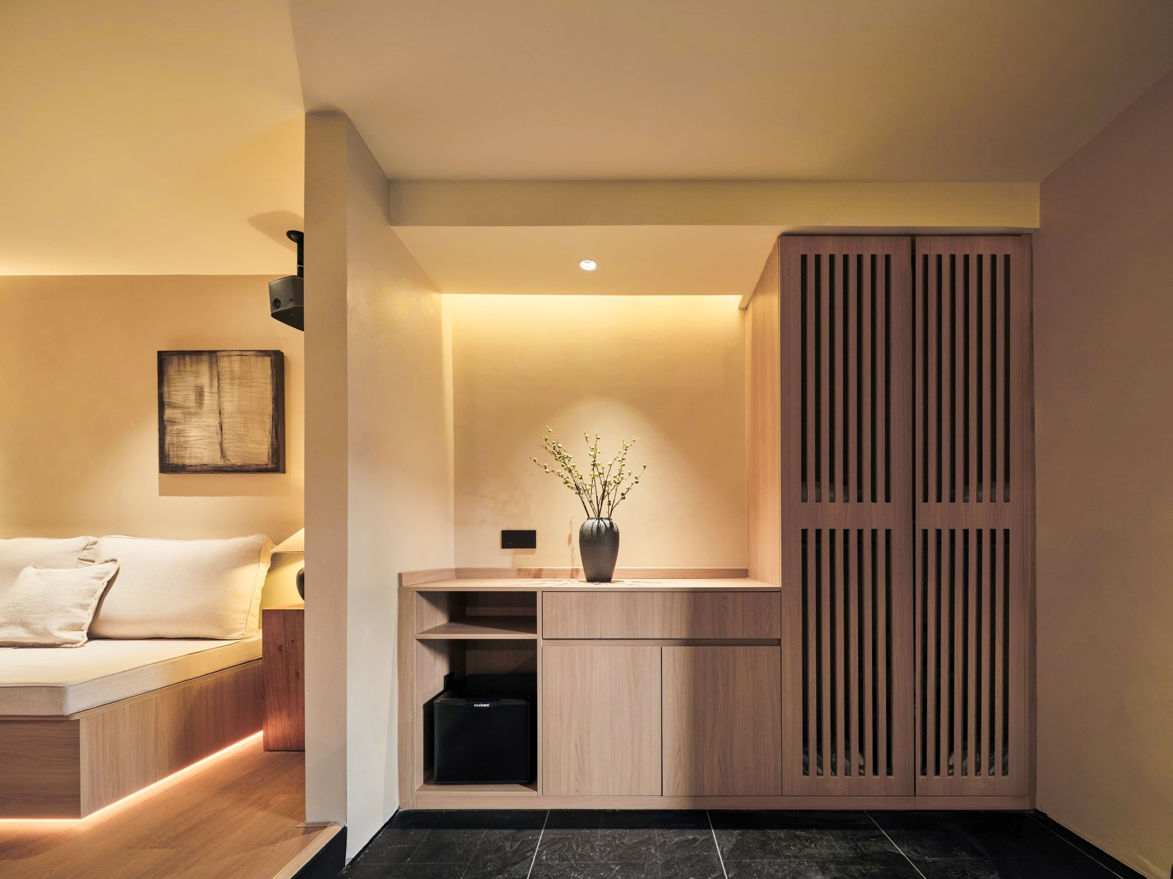 Ein modernes, minimalistisches Schlafzimmer mit Bett, Nachttisch und einer eingebauten Schrankwand mit Schiebetür.
