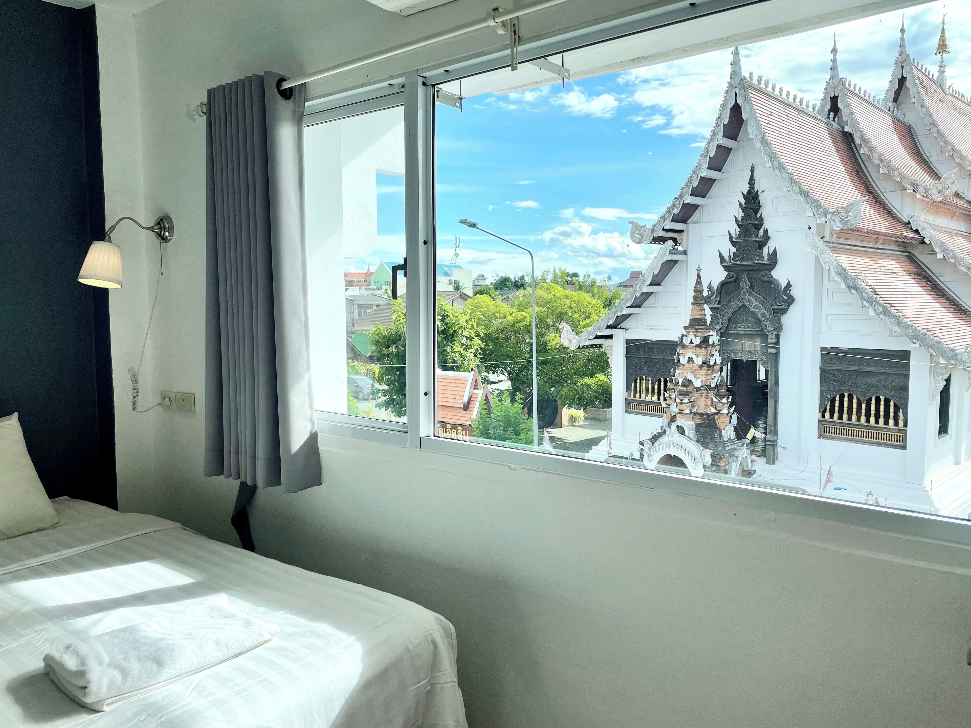 A hotel room with a large window offering a view of a traditional building with ornate architecture.