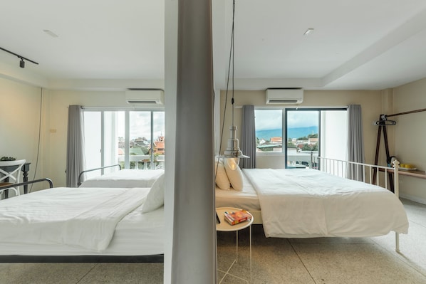 Une chambre d’hôtel avec deux lits, une petite table et une vue sur la ville.