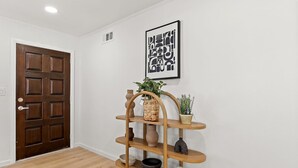 A wooden door, a wall-mounted plant shelf, and a framed abstract art piece. - 222 - New, Stylish Quiet 2B1B w/ Yard near Stanford (Redwood City)
