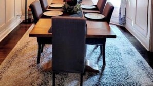 A dining area with a wooden table, six chairs, a chandelier, and a floral centerpiece. - Charming Wisconsin Dells, Devil’s Lake, & Circus World Retreat! (Baraboo)