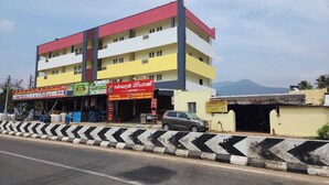 A multi-story building with commercial signage on the ground floor. - Sai Home Stay (Coimbatore)