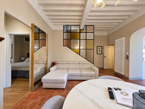 A modern interior with a staircase, a sofa, and a bed.