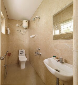 Baño con inodoro, lavamanos y ducha.