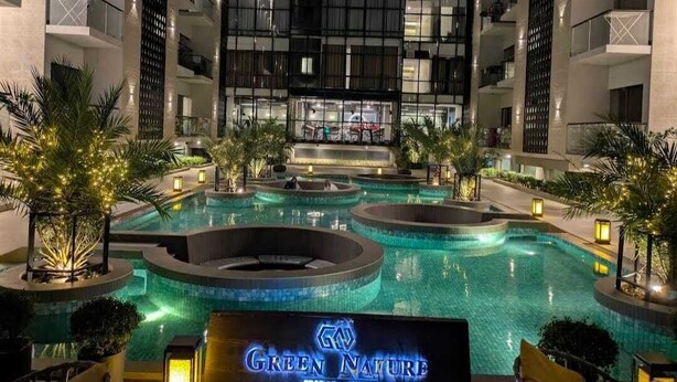 Un hôtel doté d’une grande piscine intérieure, de nombreux balcons et d’une architecture moderne.