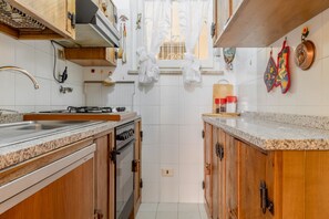 Réfrigérateur, un four, surface de cuisson, vaisselle et ustensiles