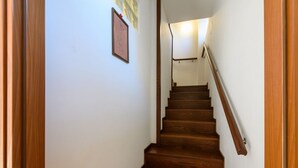 Un escalier en bois, doté d’une rampe, menant à l’étage supérieur.
