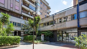 A multi-story building with a central atrium, outdoor seating area, and greenery. - GuestHost - Charming 64 sqm apartment, ideal for three people, located on the mezzanine floor of a building without a lift.The property is located in a privileged position, close to Piazza della Rinascita, the hub of city life in Pescara, and a stone's t (Pescara)