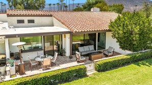 A modern house with a patio area featuring outdoor furniture and a fire pit. - Golf Course Views, Pool, Spa, Dine Al Fresco (Rancho Mirage)