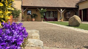 A building with a tiled roof, a stone pathway, and potted plants. - Let yourself be transported to the heart of Berry and discover our heritage. (Pouligny-Notre-Dame)