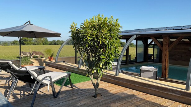 A wooden deck with lounge chairs and a pool area. - Let yourself be transported to the heart of Berry and discover our heritage. (Pouligny-Notre-Dame)