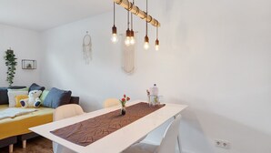 Una sala de estar moderna con un sofá, una mesa de comedor y una lámpara colgante.