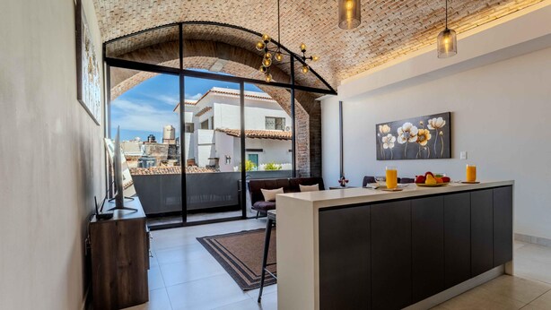 A modern kitchen with a central island, large windows, and a view of the cityscape. - Bliss 450 - Unit 2-3 Casa NuevaYol 1BD Condo for rent in Downtown, Puerto vallar (Puerto Vallarta)