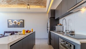 A modern kitchen with dark cabinets, a stainless steel refrigerator, a microwave, and a sink. - Bliss 450 - Unit 2-3 Casa NuevaYol 1BD Condo for rent in Downtown, Puerto vallar (Puerto Vallarta)