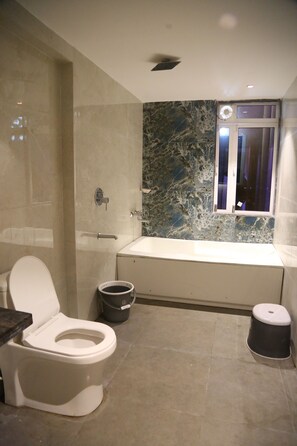 A modern bathroom with a marble sink, a toilet, and a shower area.