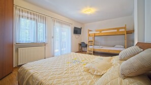 Un dormitorio con literas, un escritorio, una silla y un televisor.