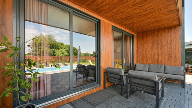 Un patio extérieur moderne avec une piscine, un canapé et un coin repas.