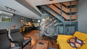 Un espace de vie moderne comprenant une cuisine, un coin repas et un escalier.