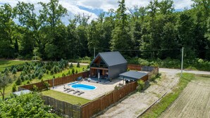 Une maison moderne dotée d’une piscine, d’un patio couvert et d’une cour clôturée.