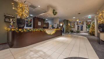 Welcome to our reception area, featuring a curved reception desk and beautifully decorated space with artwork and festive touches.