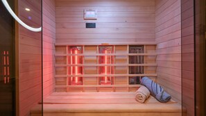 Ein Sauna-Raum mit Holzwänden, einer Sitzbank und roten Heizpaneelen.