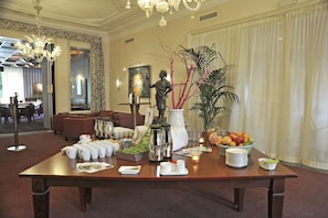 Welcome to our elegant lobby, featuring a reception desk with a coffee station, fruit bowl, and comfortable seating area.