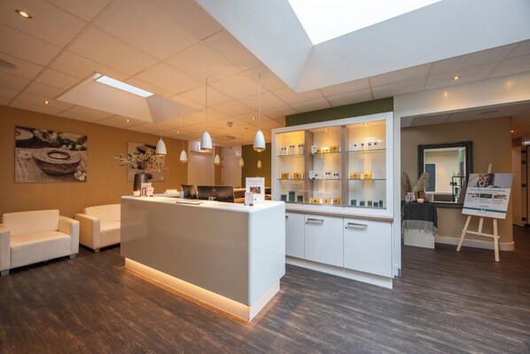 Welcome to our reception area, featuring a central desk, comfortable sofas, and artwork on the walls.