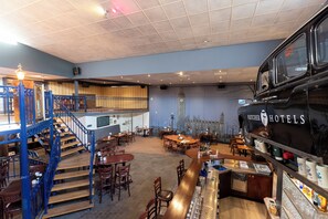 Enjoy a classic dining experience in our restaurant with a central bar, seating areas, and a unique mural.