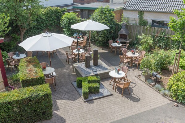 Relax in a serene outdoor space surrounded by lush greenery and comfortable seating.