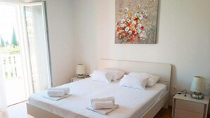 A hotel room with a large bed, two bedside tables, and a painting on the wall. - Apartments & Rooms Cakelic II (Zupa dubrovacka)