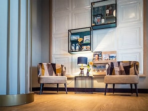 Relax in a cozy seating area with two comfortable chairs, a side table, and a decorative lamp.