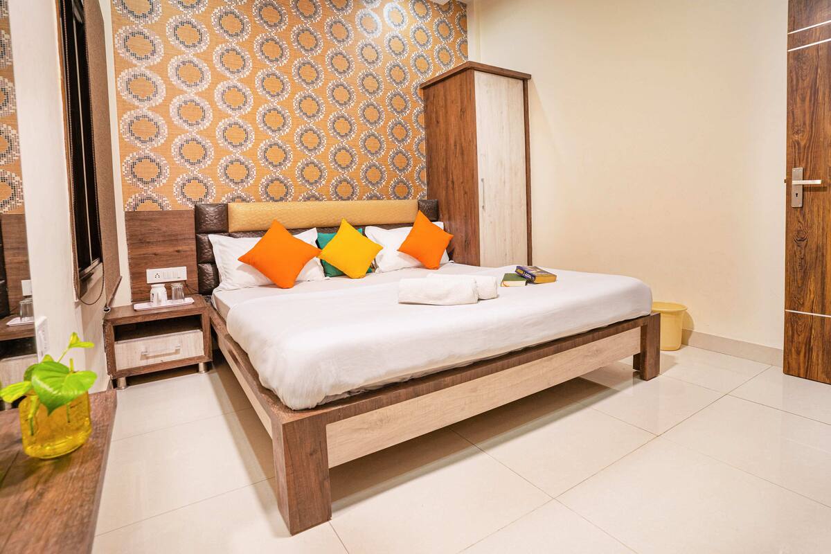 A neatly arranged bedroom with a wooden bed, a nightstand, a bedside table, and a wardrobe.