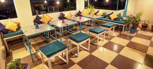 A cozy outdoor seating area with tables and benches, surrounded by potted plants. - goSTOPS Amritsar Chatiwind Gate (Amritsar)