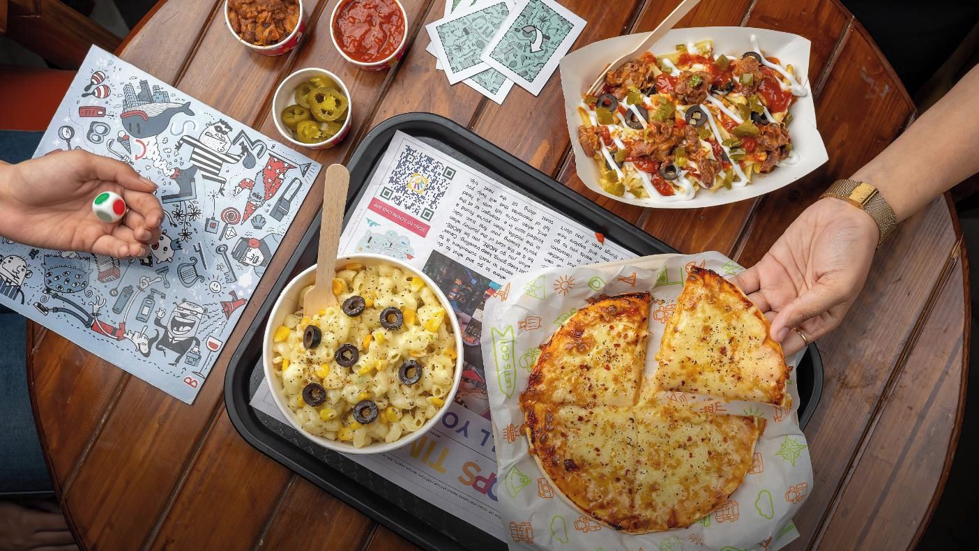 Una bandeja con comida y un código QR sobre una mesa de madera.