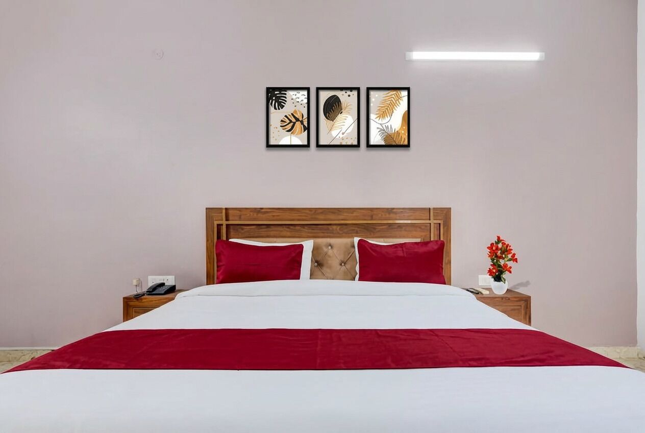 Une chambre d’hôtel avec un lit, une tête de lit en bois, une table de chevet avec un téléphone et une œuvre d’art accrochée au mur.