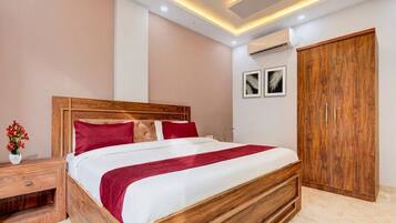 Un dormitorio con cama de madera, mesita de noche, armario y techo con iluminación empotrada.