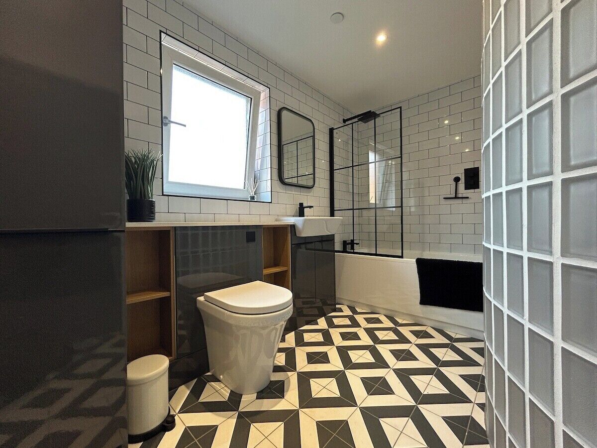 A modern bathroom with a toilet, sink, and bathtub.