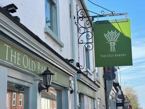 A street view with a building labeled 'THE OLD BAKERY' and a sign for 'THE OLD BAKERY' with a wheat symbol. - Stunning modern home in Lincoln (Lincolnshire)
