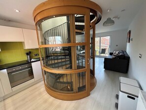 A modern kitchen with a built-in spiral staircase. - Stunning modern home in Lincoln (Lincolnshire)