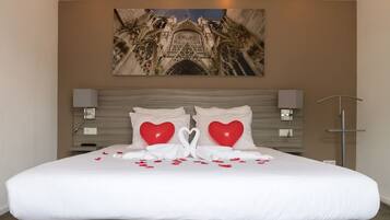 Restful retreat with a large bed, framed artwork, and bedside tables.