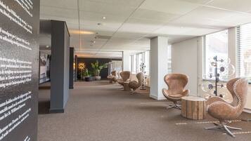 Work in comfort with a carpeted floor, upholstered chairs, and plenty of natural light.