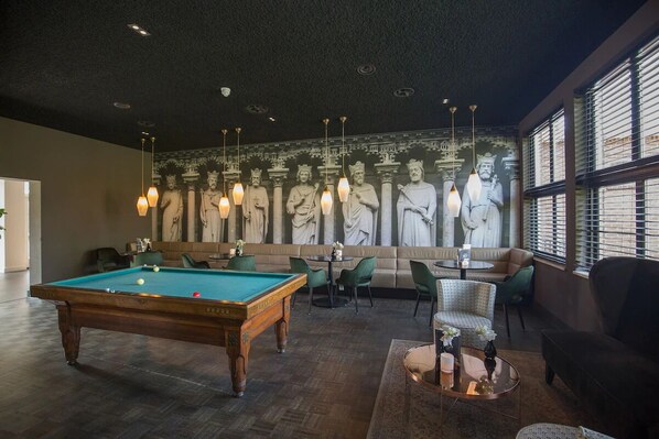 Relax in style with a pool table, comfortable seating, and a beautiful mural of classical statues.