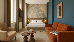 Relax in a spacious room with a large bed, comfortable seating area, and a large window offering a view.
