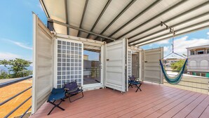Una terraza abierta con dos sillas y una hamaca.
