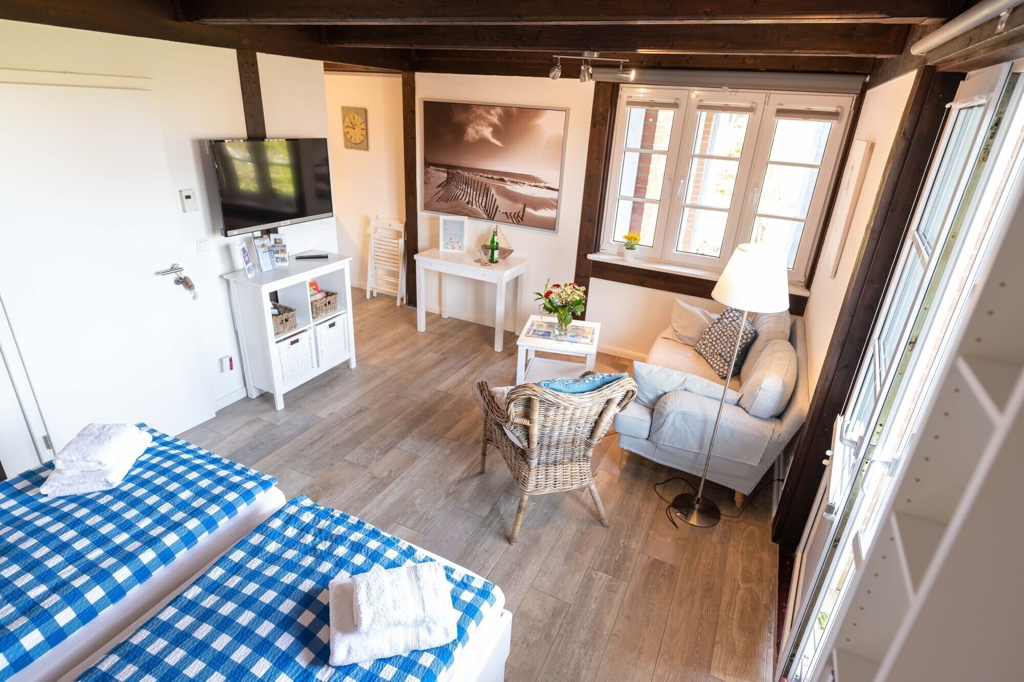 Ein gemütliches Zimmer mit einem Bett, einem Sofa, einem Fernseher, einem kleinen Tisch und einem Fenster.