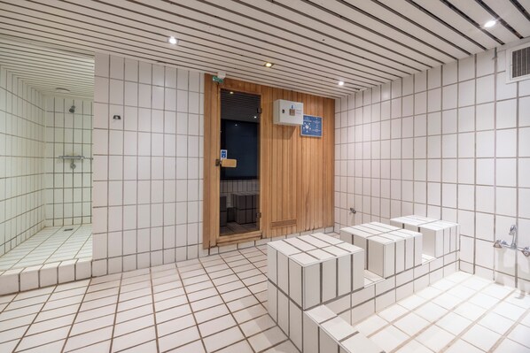 Modern bathroom with a shower area, storage units, and a door leading to a separate space.